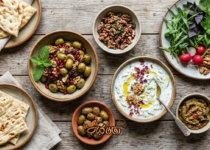 Traditional Gilani accompaniments, including *zeytoon-e parvardeh* (marinated olives) and walnuts, for the dinner party spread.